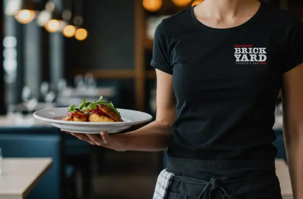 Brickyard logo on waitress shirt serving food